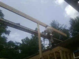 Carpenter setting a ridge beam over a new addition frame — Ice Dam Removal by Roofing Brothers in Baton Rouge