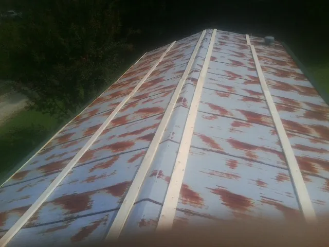 Rusted metal roof panels with new wood purlins before replacement — Storm Damage Roof Repair in Baton Rouge by Roofing Brothers