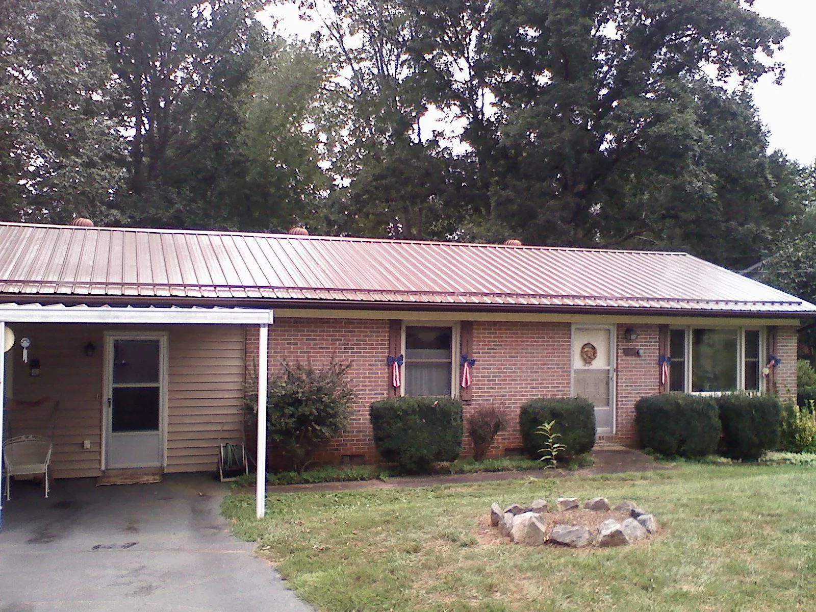 Bronze metal roof and carport on a brick ranch home — Roof Repair work by our crew in Baton Rouge