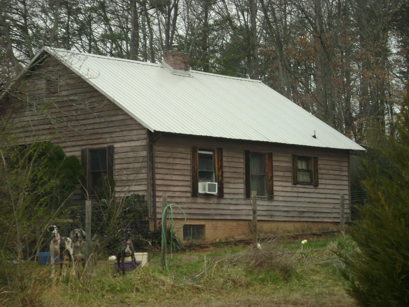 White metal roof on an old wood sided farmhouse, from a Metal Roof Installation job in Baton Rouge